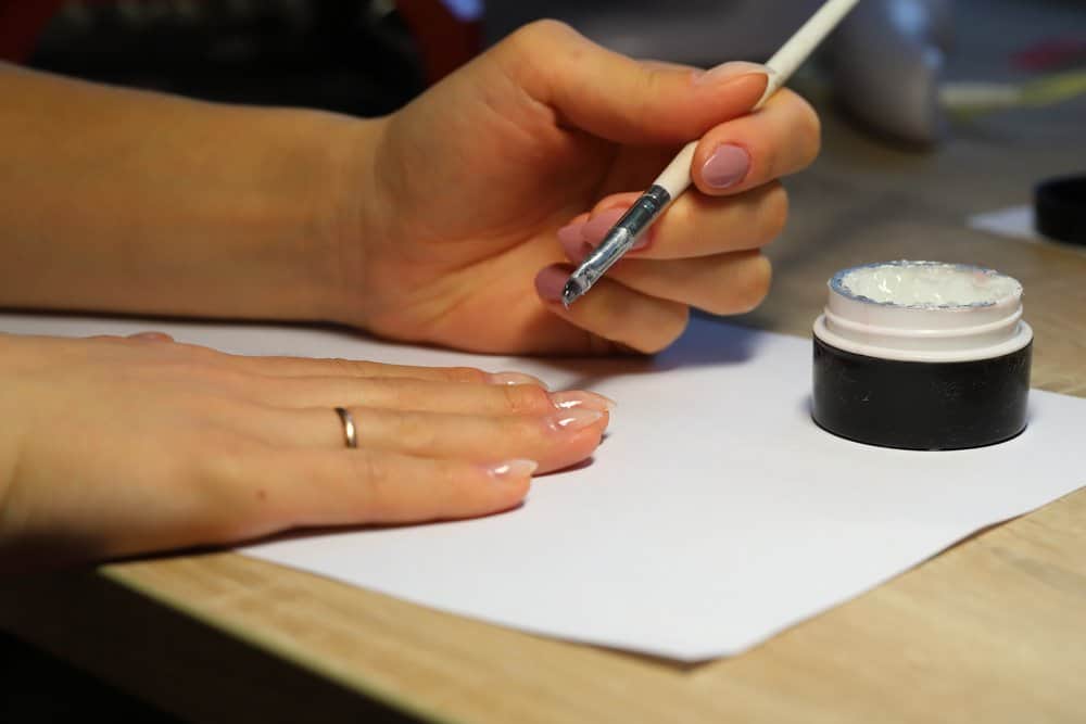 woman applying nail strenghener