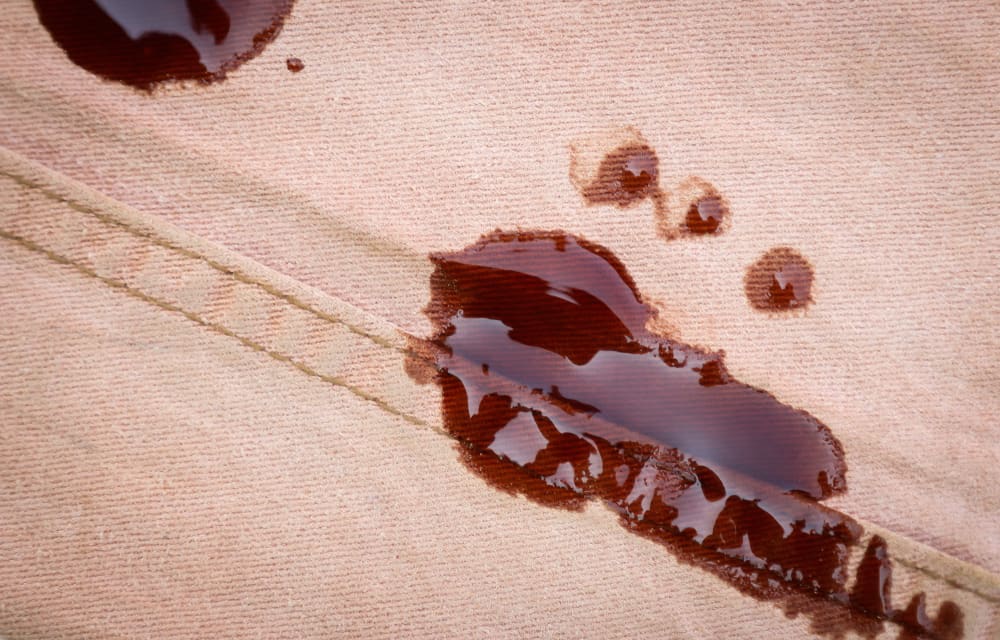 Close up of brown sauce stain on light brown jeans