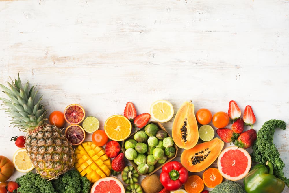 an array of fruits and vegetables sitting on a table