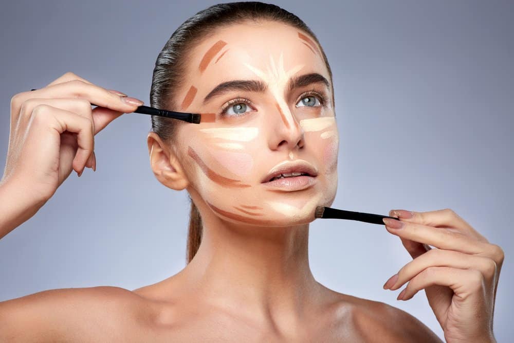 woman having her makeup done, with unblended lines of contour and highlight to show placement