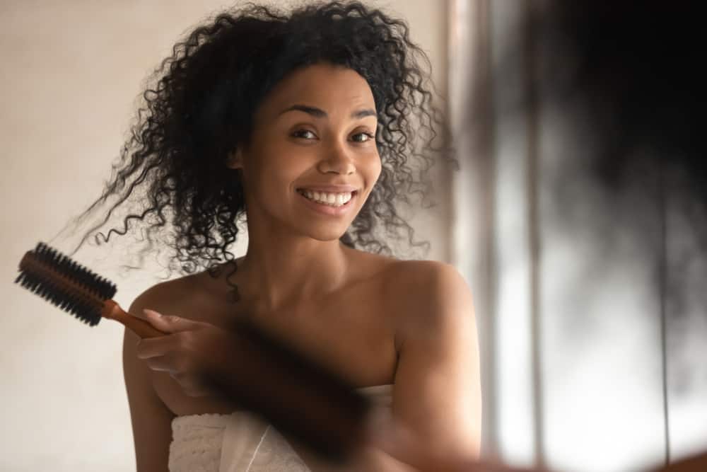 woman combing her curly hair