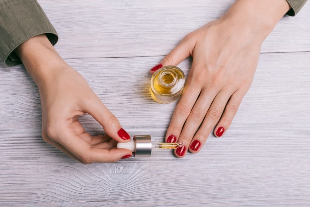 woman applying oil to nails