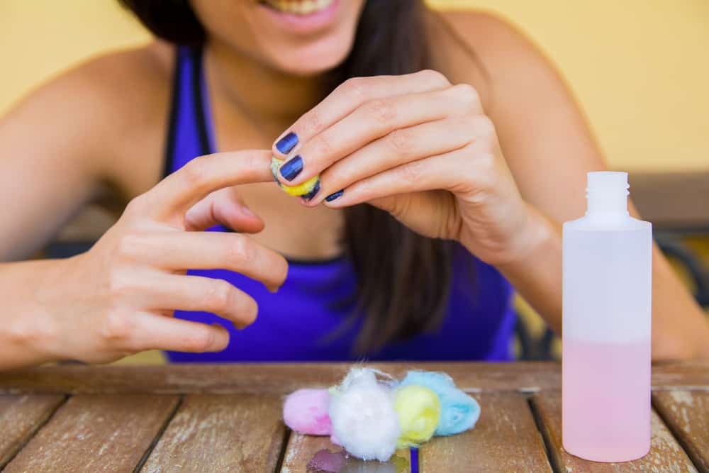 woman smiling while removing nail polish