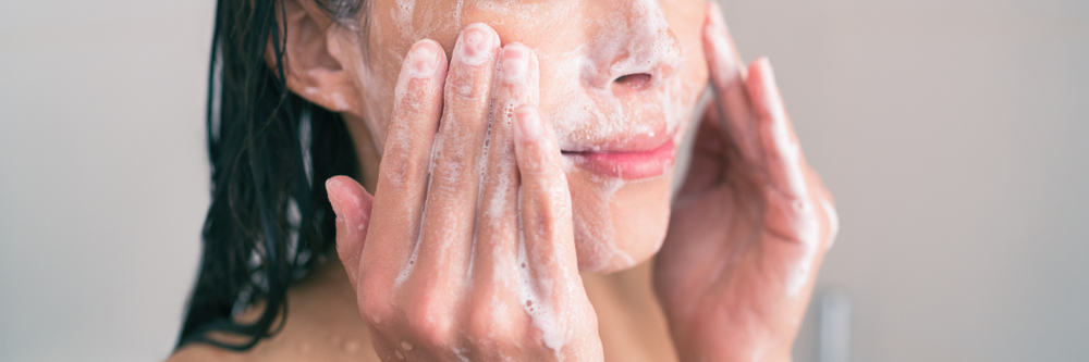 woman washing face with soap