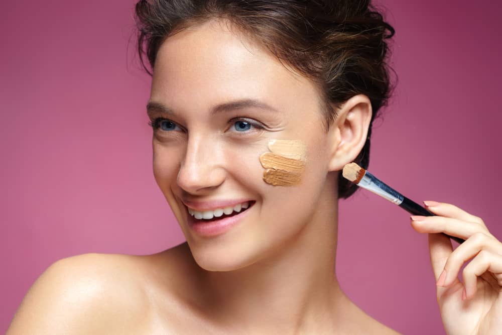 woman applying foundation