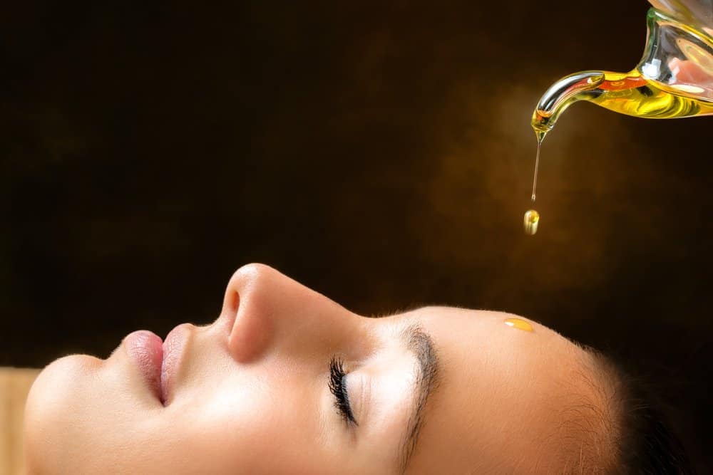 woman using rosehip oil on face