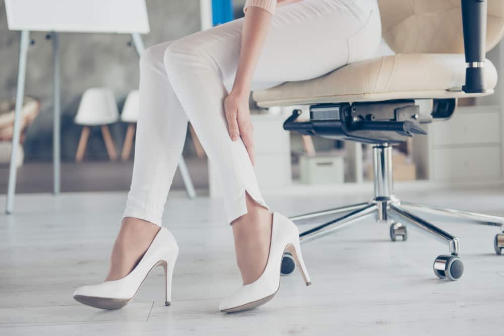 woman in office chair wearing white pumps