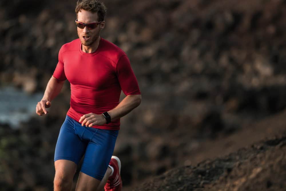 male athlete jogging through trail