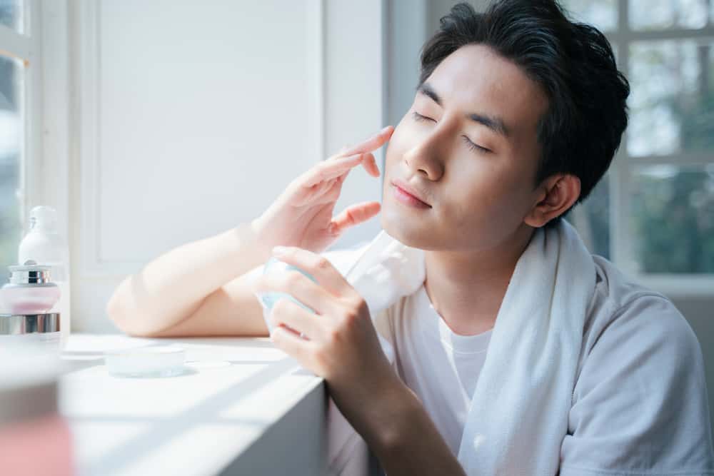 man applying face cream