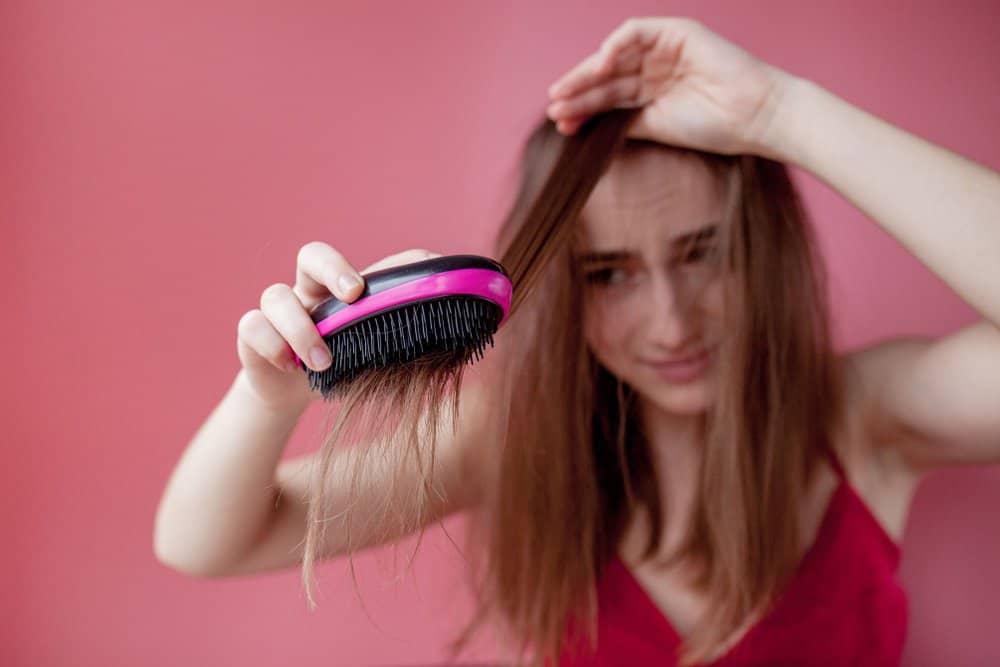 girl struggling to brush hair