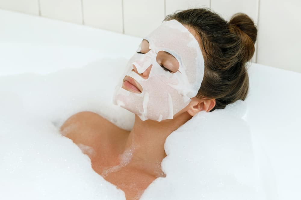 women wearing sheet mask in bubble bath