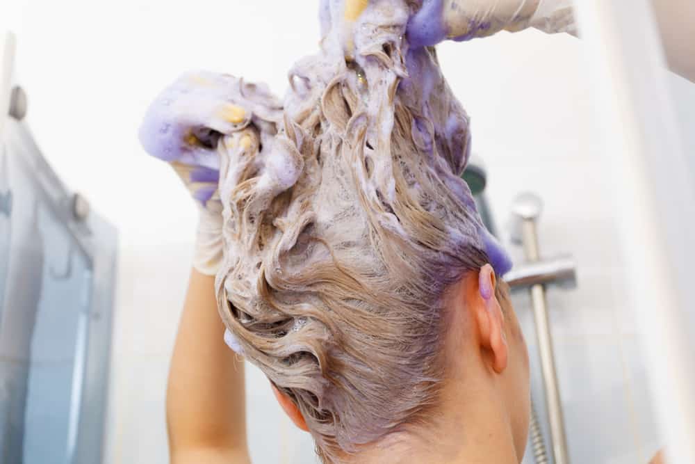 women applying purple shampoo