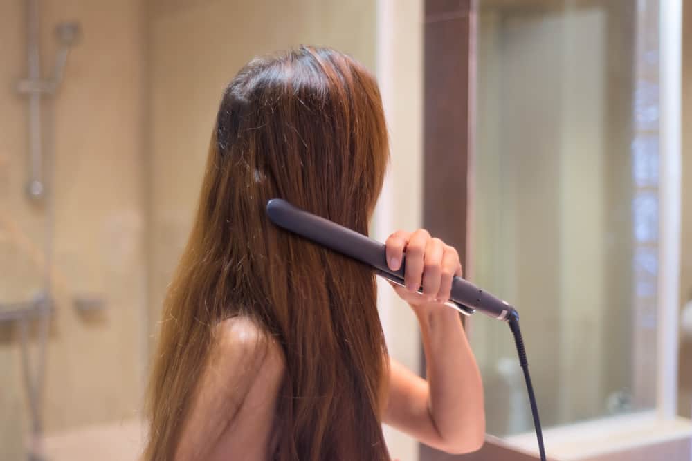 woman straightening hair