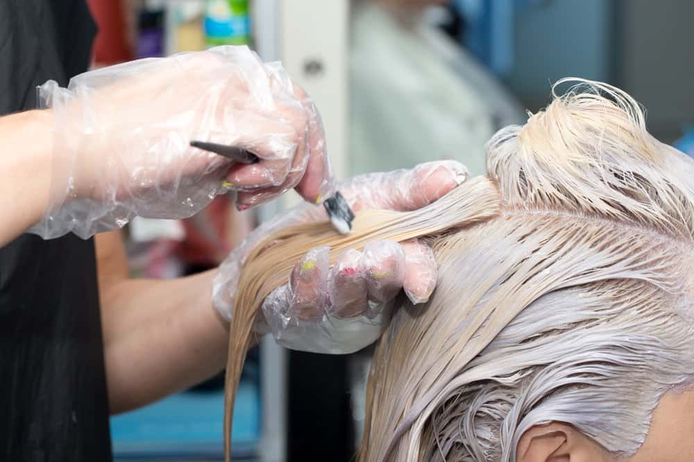 stylist bleaching customer’s hair