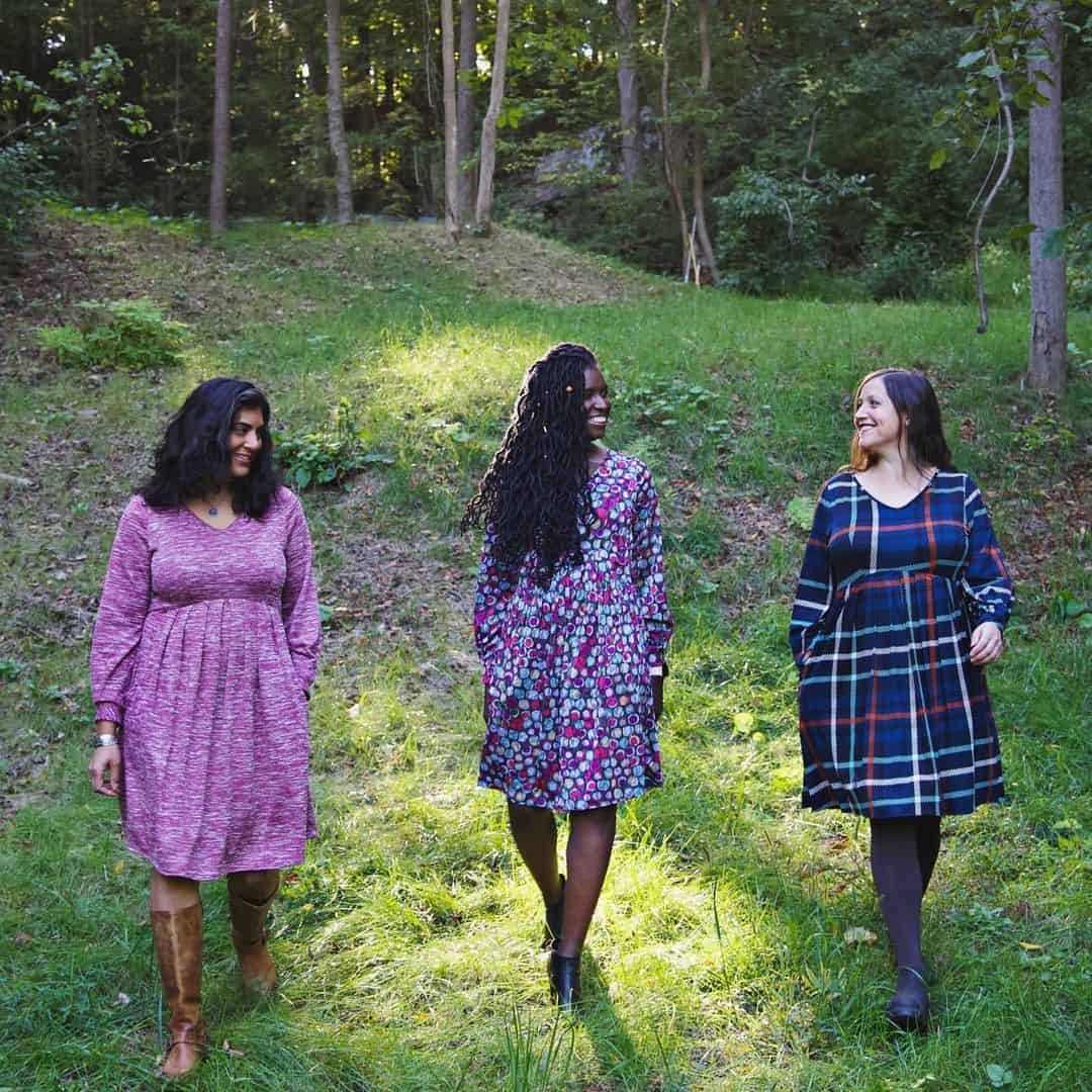 Three models in the forest in knee-length dresses