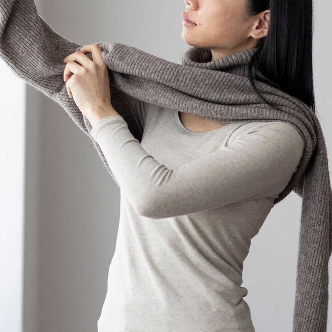 Woman pulling on a sweater