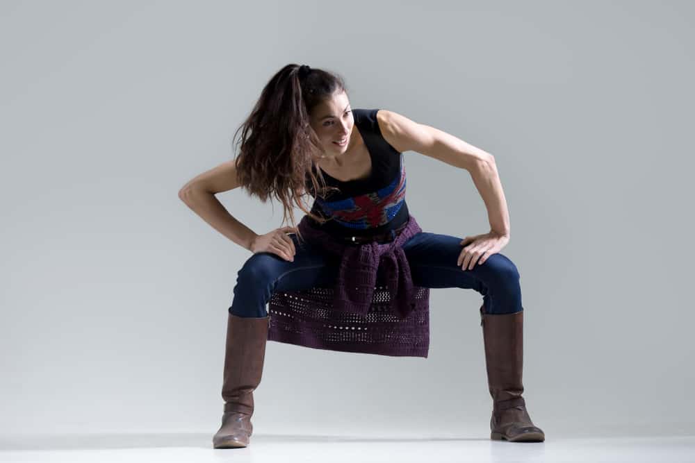 a young woman exercises while wearing a pair of jeans