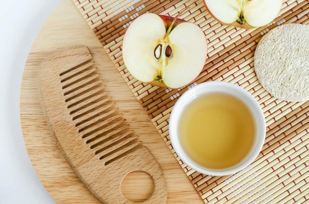 apple half and vinegar and wooden comb