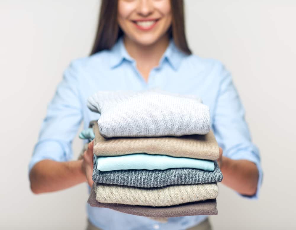 happy woman with folded clothes