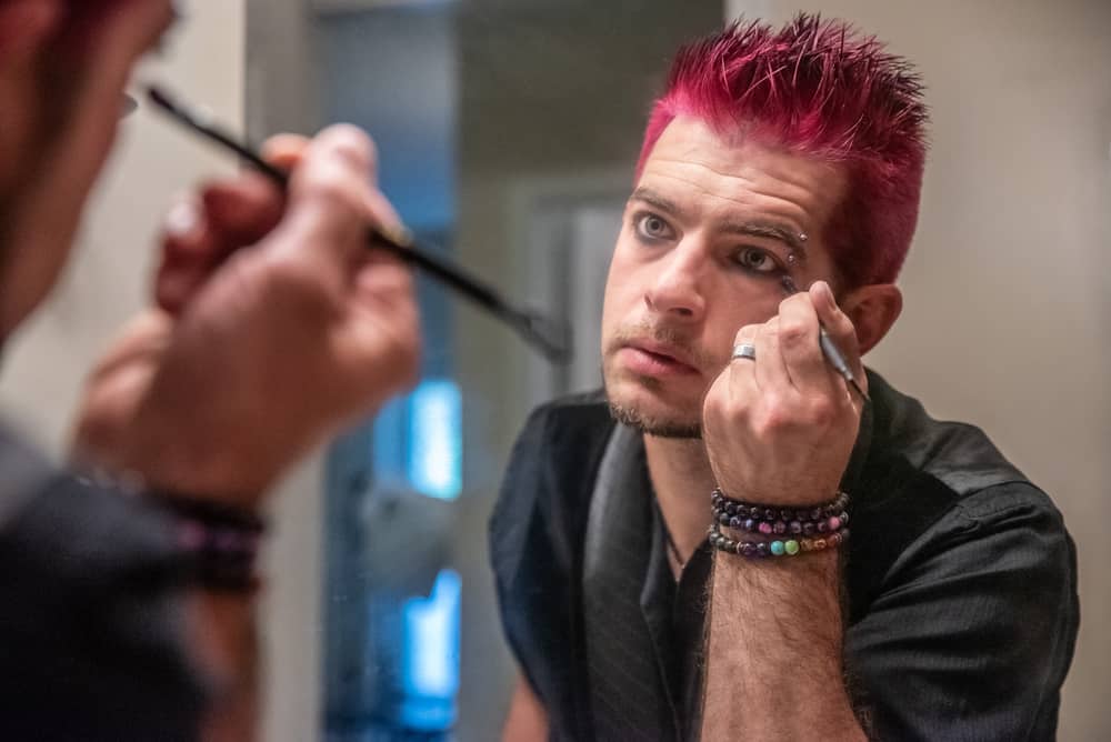 man applying punk eyeliner