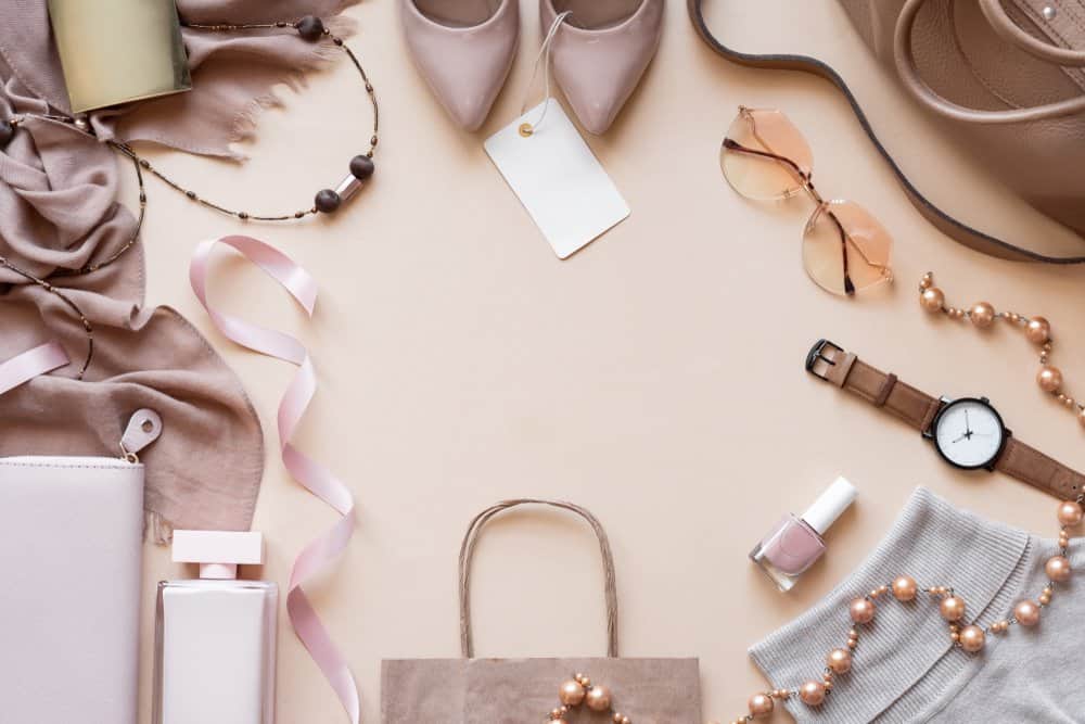 overhead shot of clothes and accessories against beige background