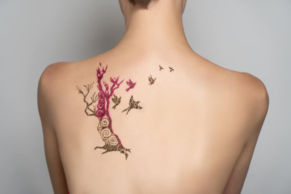 purple and black tree tattoo on back