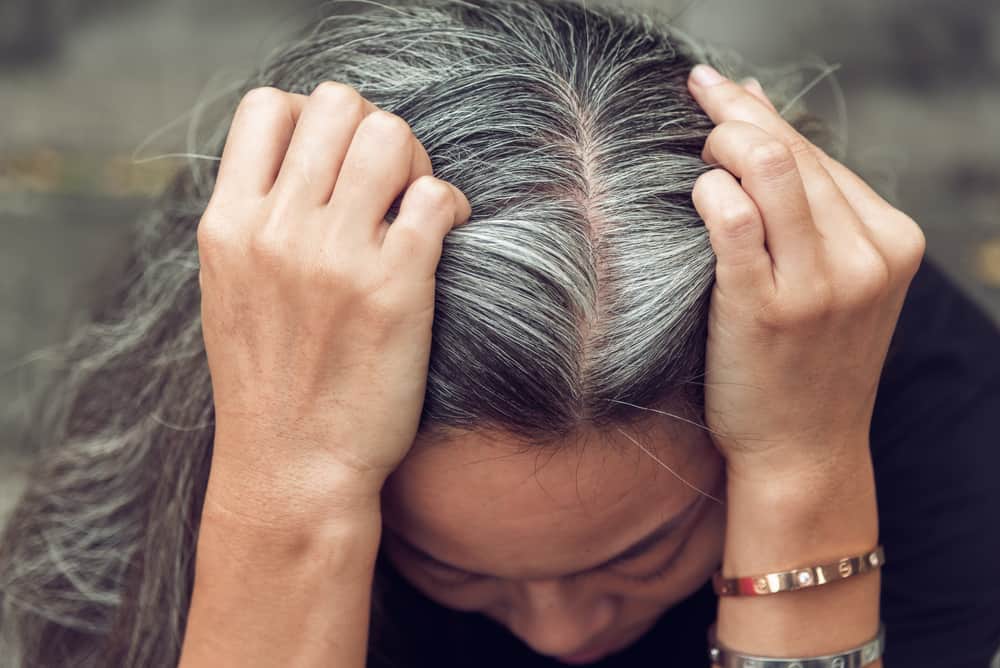 woman holding head in pain