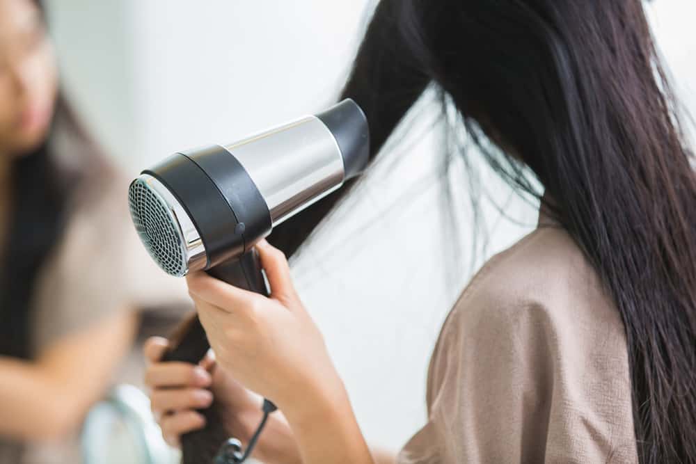 woman using hair dryer