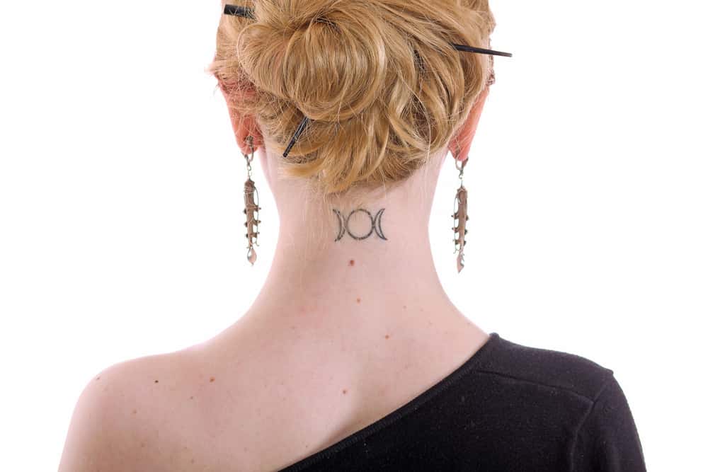 woman with triple goddess tattoo on neck