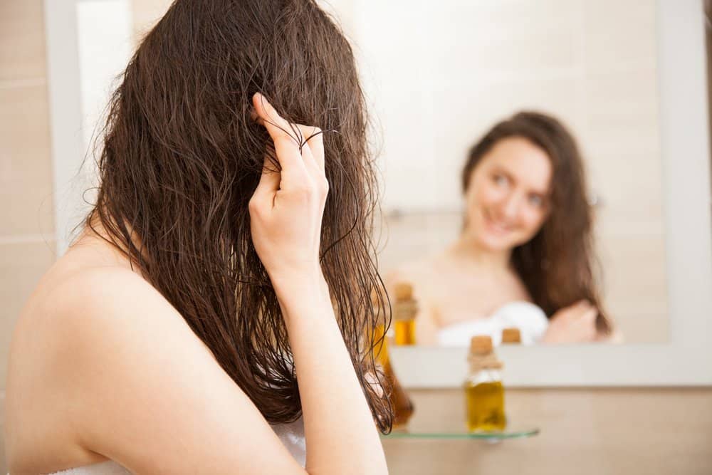 woman applying hair nourishing treatments