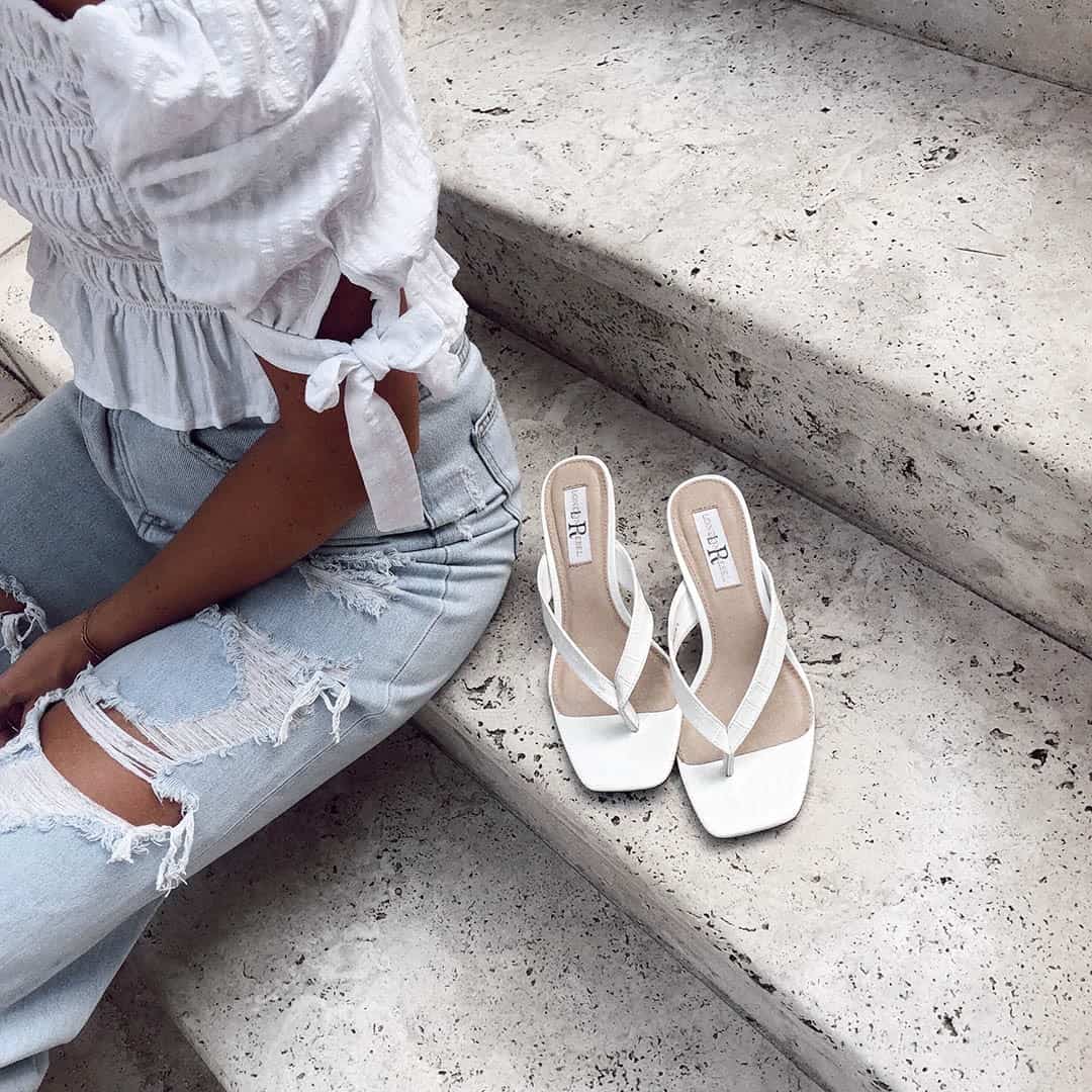 woman sitting by famous footwear shoes