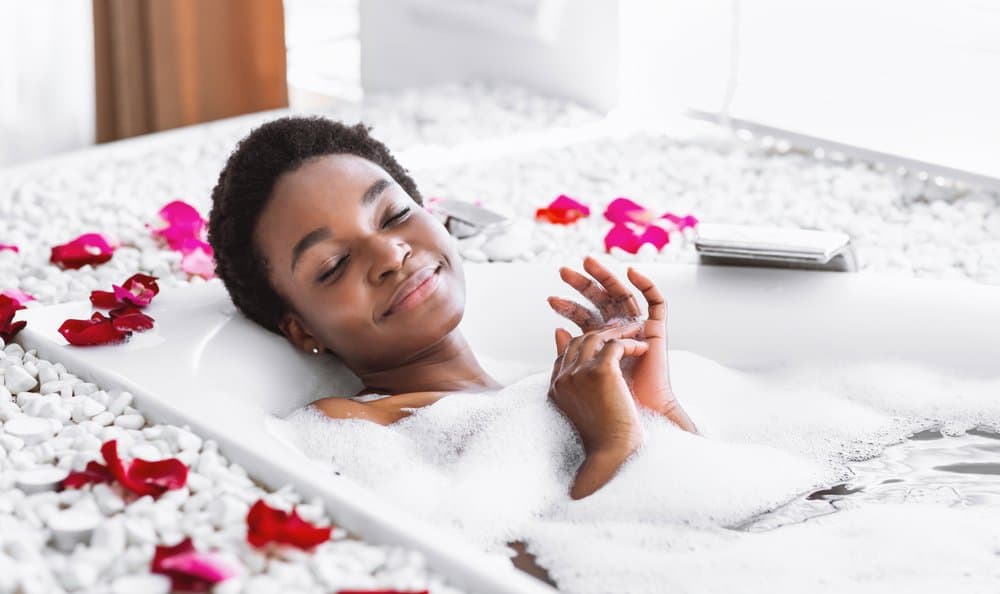 woman smiling bath bubbles flowers