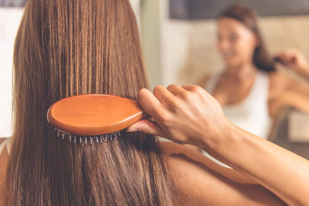 woman brushing through smooth hair