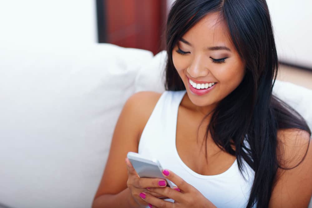 woman smiling at her phone