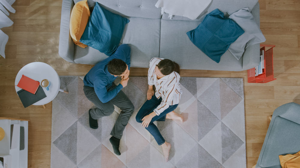 young couple sitting on floor talking