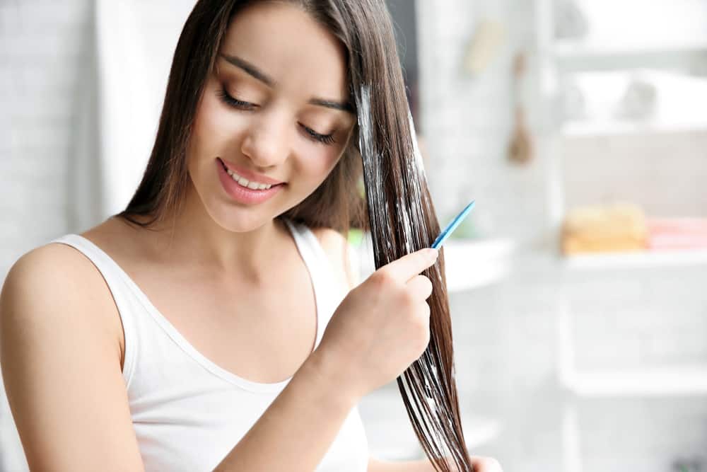 woman brushing hair mask through hair