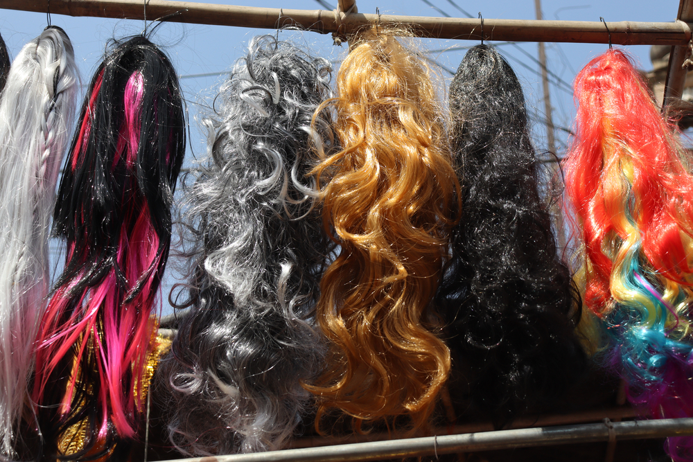 wigs hanging together outside